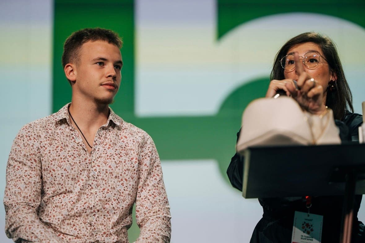 Semyon speaking on stage at a public event.